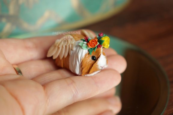 Langhaarige Meerschweinchen Figur mit Flügeln und Blumenkrone in orange und gelb