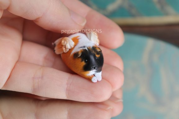 Dreifarbige Meerschweinchen Figur mit Flügeln und gestreckten Pfoten