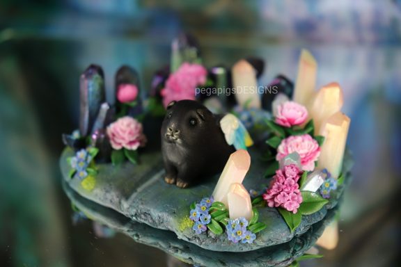 Skulptur mit verschiedenen rosa Blüten und hellen und dunklen Kristallen aus FIMO. 