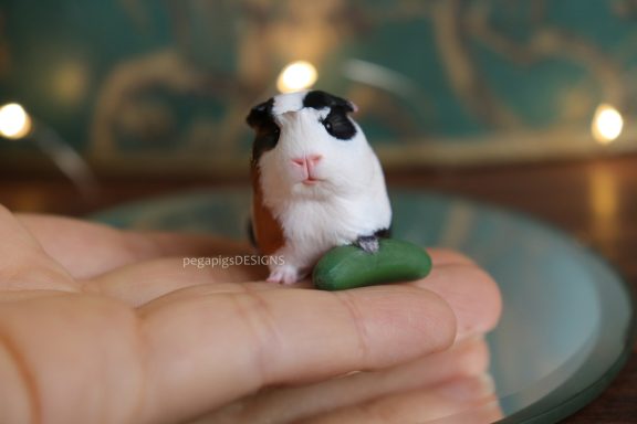 Dreifarbige Meerschweinchen Figur mit Miniatur Gurke