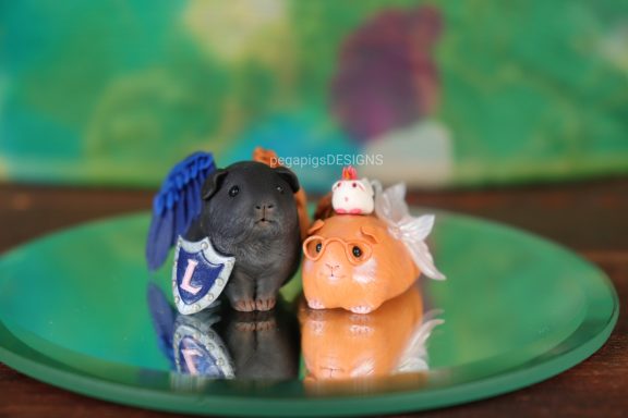 Pärchen Figur bestehend aus einem dunklen Meerschweinchen und einem hellen Meerschweinchen mit Brille und Flügeln