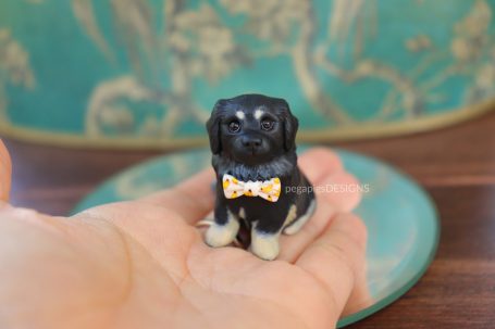 Schwarzer Hund als Miniatur Skulptur mit Bananen-Fliege